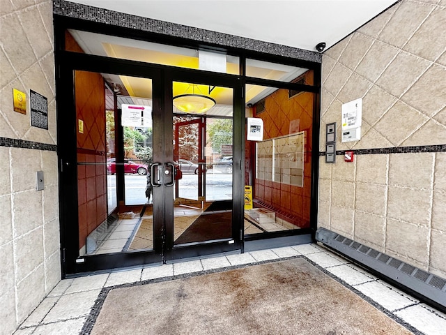 1600 Parkview Ave Unit 6A, Bronx, NY 10461 - doorway to outside featuring tile walls, inlaid floor details, french doors, and stone tile floors