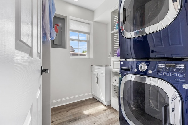 270 Farmers Ave, Lindenhurst, NY 11757 - laundry area featuring estacked washer and dryer, cabinet space, light wood-style floors, and electric panel