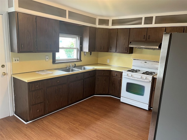 8 Gables Rd, Hicksville, NY 11801 - kitchen with white gas range oven, range hood, freestanding refrigerator, dark brown cabinets, and light countertops