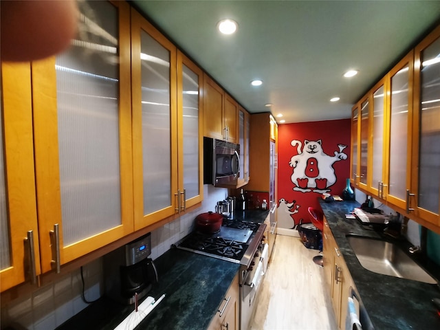 33-47 91st St Unit 5A, Jackson Heights, NY 11372 - kitchen with recessed lighting, brown cabinetry, light wood-type flooring, glass insert cabinets, and dark stone counters