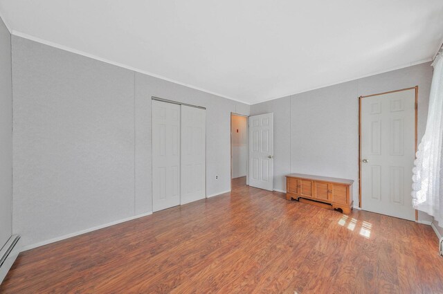 16 Marlin Rd, Centereach, NY 11720 - unfurnished bedroom with wood finished floors, ornamental molding, a closet, and a baseboard heating unit