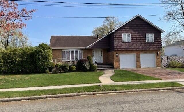 28 Jansen St, Staten Island, NY 10312 - tri-level home featuring an attached garage, driveway, and a front lawn