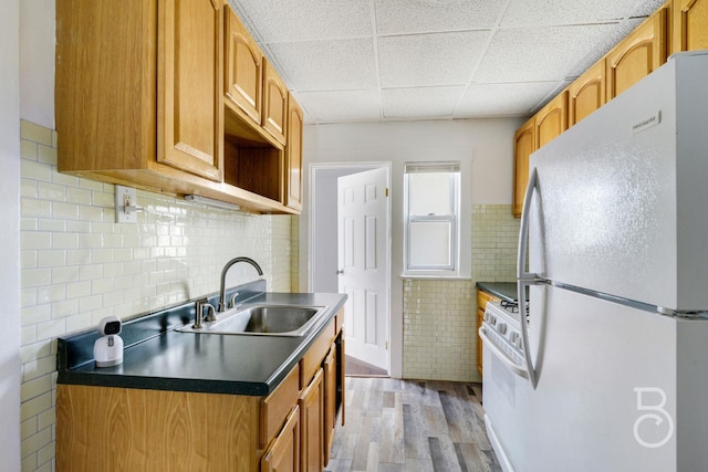 27-12 Ditmars Blvd, Astoria, NY 11105 - kitchen with white appliances, light wood-style floors, tile walls, dark countertops, and a paneled ceiling