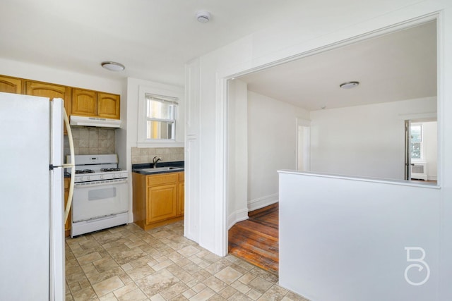 27-12 Ditmars Blvd, Astoria, NY 11105 - kitchen featuring white appliances, under cabinet range hood, decorative backsplash, and stone finish flooring