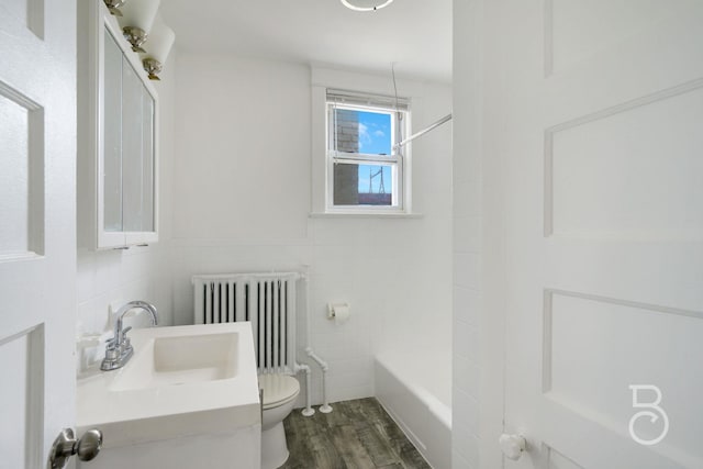 27-12 Ditmars Blvd, Astoria, NY 11105 - bathroom with radiator heating unit, tile walls, wood finished floors, and shower / tub combination