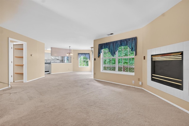 307 Gazebo Ct, New Windsor, NY 12553 - unfurnished living room with a tiled fireplace, light colored carpet, and a chandelier