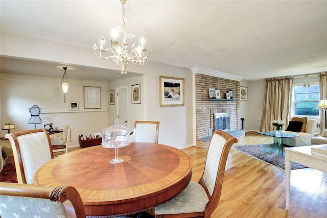 59 Russell Rd, Garden City, NY 11530 - dining space featuring light wood-style flooring, a brick fireplace, and a chandelier