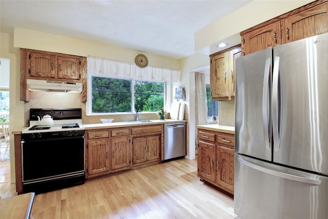 59 Russell Rd, Garden City, NY 11530 - kitchen with stainless steel appliances, under cabinet range hood, light wood finished floors, light countertops, and tasteful backsplash