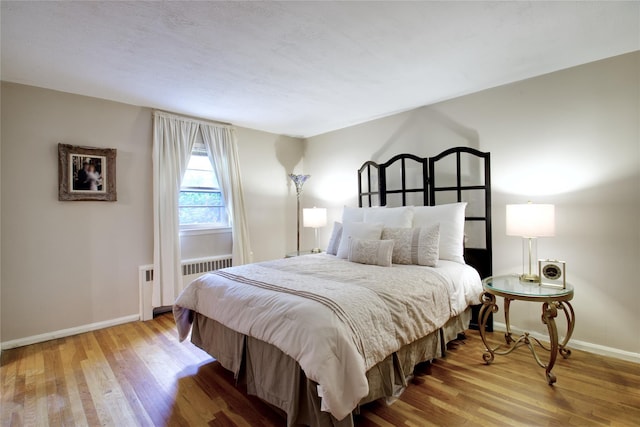 59 Russell Rd, Garden City, NY 11530 - bedroom featuring radiator heating unit and wood finished floors