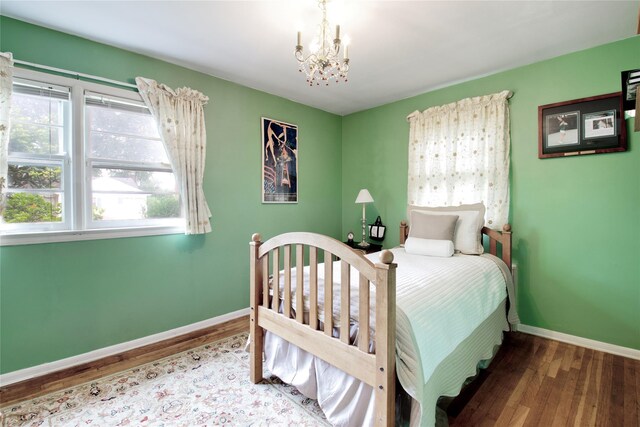 59 Russell Rd, Garden City, NY 11530 - bedroom with a chandelier, wood finished floors, and multiple windows