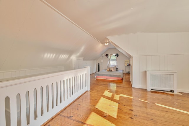 202 Roosevelt Ave, Valley Stream, NY 11581 - bonus room featuring hardwood / wood-style floors, lofted ceiling, radiator heating unit, and a decorative wall