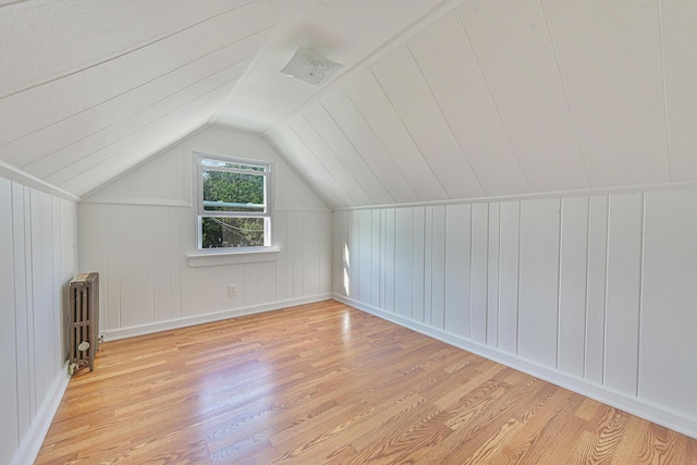 202 Roosevelt Ave, Valley Stream, NY 11581 - additional living space with radiator, wood finished floors, vaulted ceiling, and a decorative wall