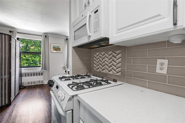 3 Birchwood Ct # 5K, Mineola, NY 11501 - kitchen featuring white appliances, radiator, white cabinetry, decorative backsplash, and dark wood-style floors