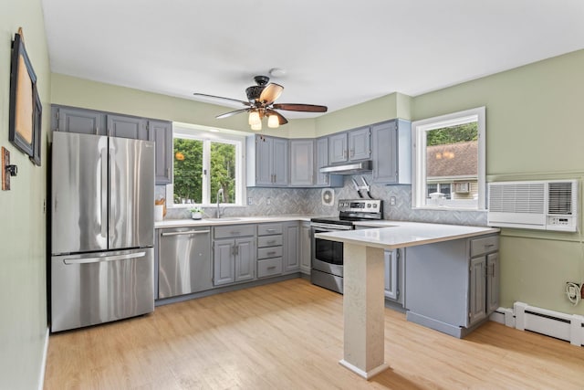10 Elm Ave, Smithtown, NY 11787 - kitchen featuring appliances with stainless steel finishes, gray cabinets, under cabinet range hood, light wood-type flooring, and light countertops