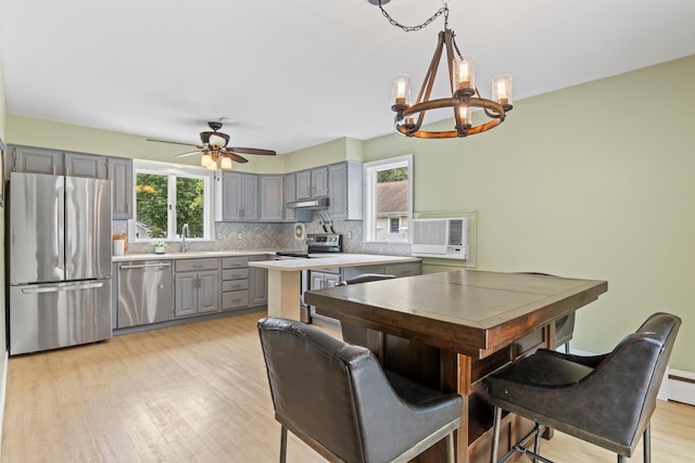 10 Elm Ave, Smithtown, NY 11787 - kitchen with stainless steel appliances, gray cabinetry, a chandelier, light countertops, and under cabinet range hood