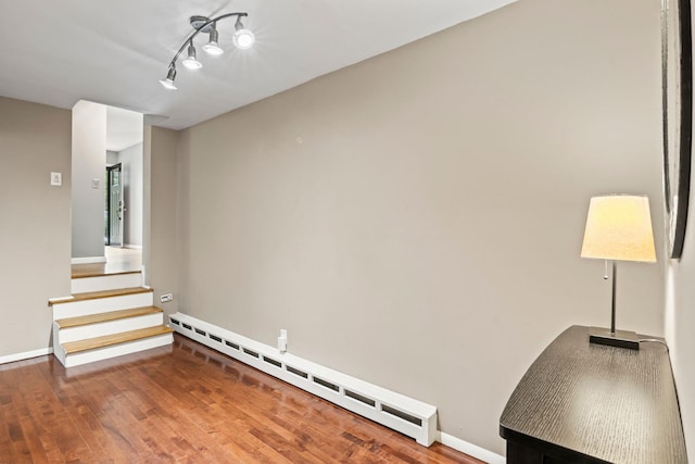 10 Elm Ave, Smithtown, NY 11787 - empty room featuring a baseboard heating unit, wood finished floors, and rail lighting