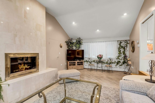 102 Bayview Ave, East Islip, NY 11730 - living room with lofted ceiling, wood finished floors, a fireplace, recessed lighting, and a baseboard heating unit
