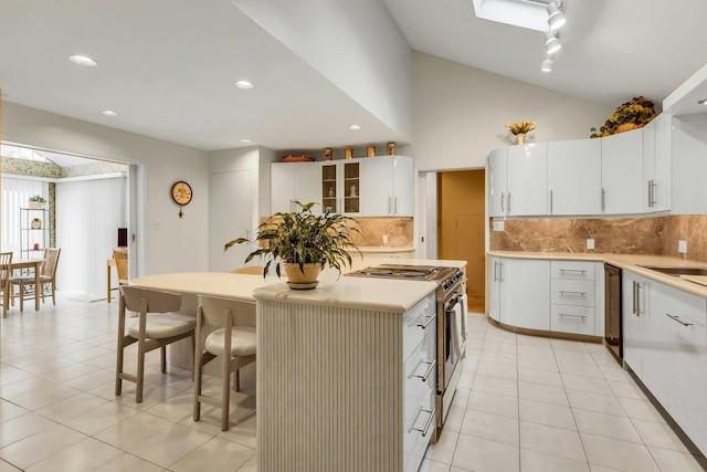 102 Bayview Ave, East Islip, NY 11730 - kitchen featuring stainless steel range oven, a kitchen bar, light tile patterned floors, decorative backsplash, and a kitchen island