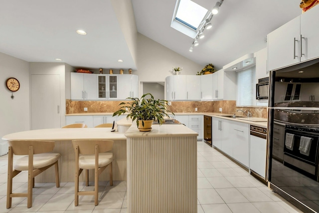 102 Bayview Ave, East Islip, NY 11730 - kitchen featuring a kitchen island, a skylight, a kitchen breakfast bar, backsplash, and lofted ceiling