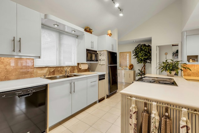 102 Bayview Ave, East Islip, NY 11730 - kitchen with black appliances, light tile patterned floors, backsplash, light countertops, and white cabinetry