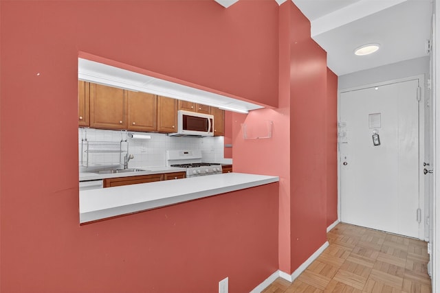 6 Fordham Hill Oval Unit 14B, Bronx, NY 10468 - kitchen with white appliances, decorative backsplash, brown cabinets, light countertops, and a peninsula