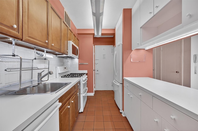 6 Fordham Hill Oval Unit 14B, Bronx, NY 10468 - kitchen featuring white appliances, light countertops, decorative backsplash, light tile patterned floors, and brown cabinets