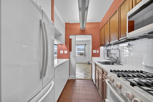 6 Fordham Hill Oval Unit 14B, Bronx, NY 10468 - kitchen with white appliances, light countertops, decorative backsplash, brown cabinets, and baseboard heating