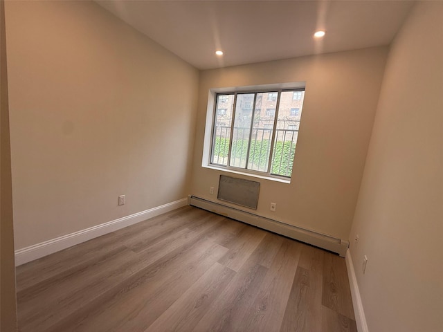 3113 137th St, Flushing, NY 11354 - empty room featuring a baseboard radiator, wood finished floors, and recessed lighting