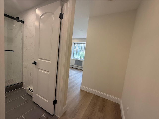 3113 137th St, Flushing, NY 11354 - corridor with a baseboard heating unit, a barn door, and dark wood-style floors