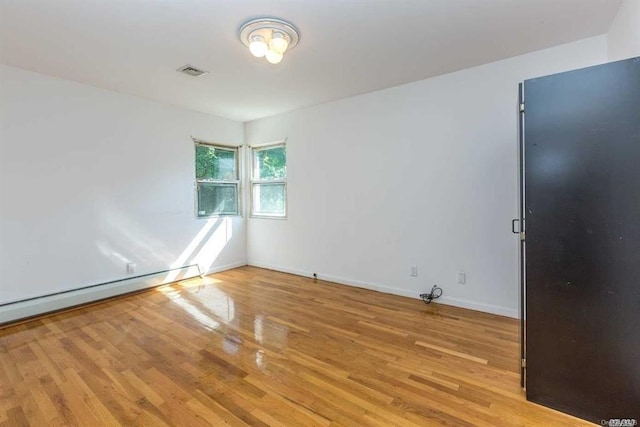 222-60 Birmington Pkwy, Bayside, NY 11364 - spare room featuring wood finished floors and a baseboard heating unit