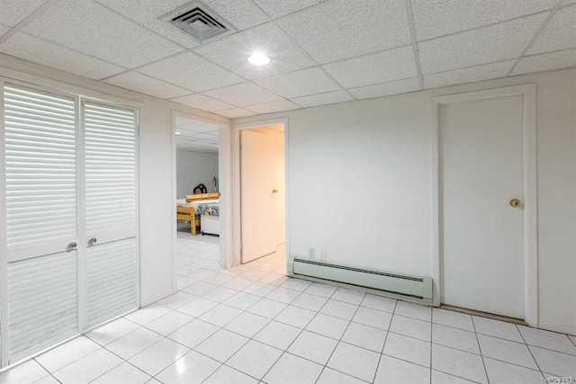 222-60 Birmington Pkwy, Bayside, NY 11364 - unfurnished bedroom featuring a baseboard heating unit, a drop ceiling, and light tile patterned floors