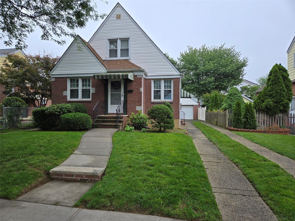 8251 257th St, Glen Oaks, NY 11004 - bungalow with brick siding, a detached garage, and an outdoor structure