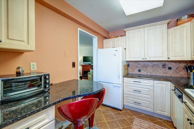 370 Westchester Unit 3N, Port Chester, NY 10573 - kitchen with white appliances, backsplash, dark stone counters, a breakfast bar area, and tile patterned floors