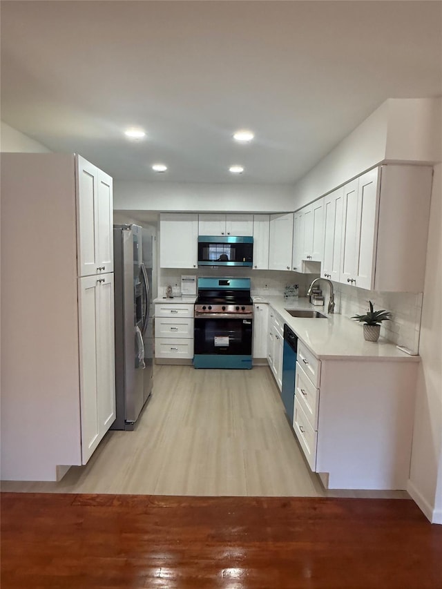22 Hulse St, Wallkill, NY 12589 - kitchen with stainless steel appliances, light wood-style floors, light countertops, white cabinets, and recessed lighting