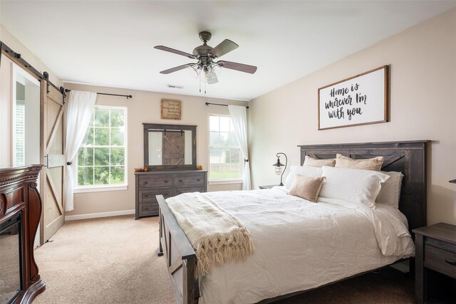 6 Danamarie Ln, East Patchogue, NY 11772 - bedroom with light colored carpet, a barn door, and a ceiling fan