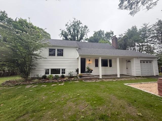 24 Sheffield Ln, Northport, NY 11768 - split level home featuring a garage, a chimney, and a front lawn