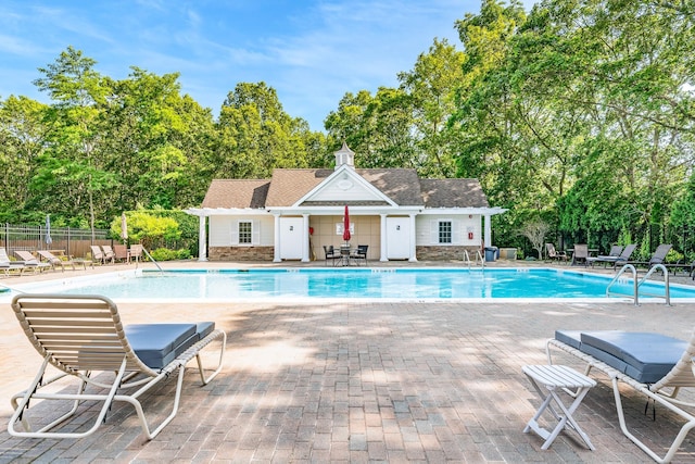 460 Old Town Rd Unit 26P, Port Jefferson Station, NY 11776 - community pool featuring view of wooded area, a patio, and an outbuilding