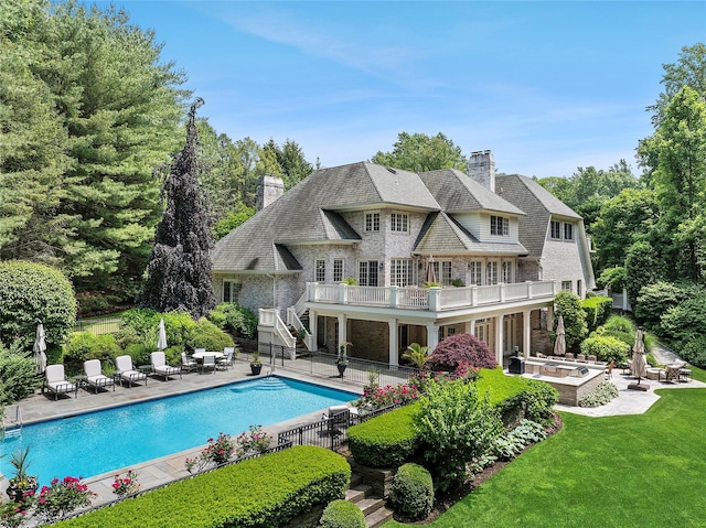 4 Pond Ln, Sands Point, NY 11050 - back of house featuring a patio, a chimney, stairs, an outdoor pool, and a balcony
