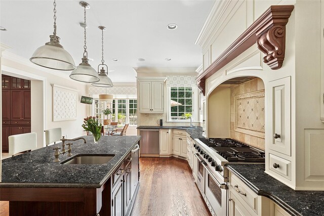 4 Pond Ln, Sands Point, NY 11050 - kitchen with appliances with stainless steel finishes, wood finished floors, ornamental molding, a center island with sink, and decorative backsplash