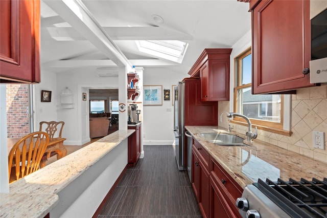 165 Bay Walk, Ocean Beach, NY 11770 - kitchen with reddish brown cabinets, a skylight, light stone counters, and tasteful backsplash