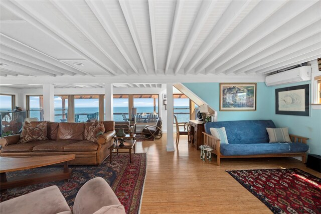 165 Bay Walk, Ocean Beach, NY 11770 - living area featuring a wall unit AC, wood finished floors, a water view, and beam ceiling