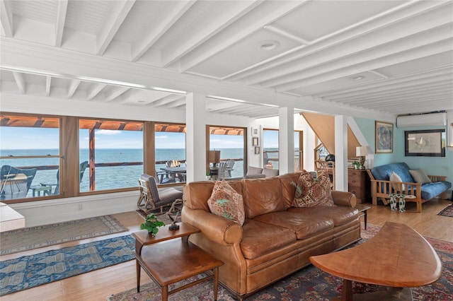 165 Bay Walk, Ocean Beach, NY 11770 - living area featuring wood finished floors, a water view, healthy amount of natural light, beamed ceiling, and a wall unit AC