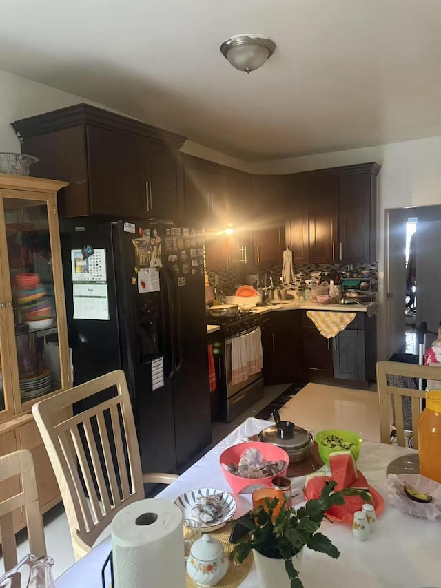 106-09 Otis Ave, Corona, NY 11368 - kitchen featuring gas range, black fridge with ice dispenser, backsplash, light countertops, and dark brown cabinets