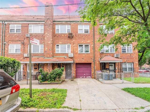 40-04 149th St, Flushing, NY 11354 - townhome / multi-family property with a garage, concrete driveway, brick siding, a chimney, and cooling unit