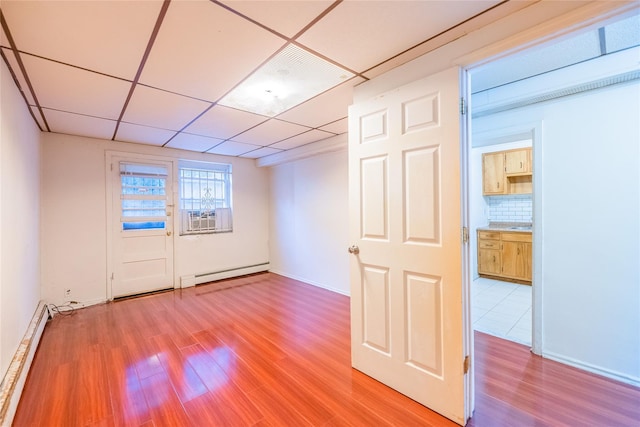 40-04 149th St, Flushing, NY 11354 - spare room with baseboard heating, a baseboard heating unit, light wood finished floors, a paneled ceiling, and cooling unit