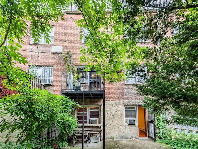 40-04 149th St, Flushing, NY 11354 - back of house featuring a balcony, brick siding, cooling unit, and a patio