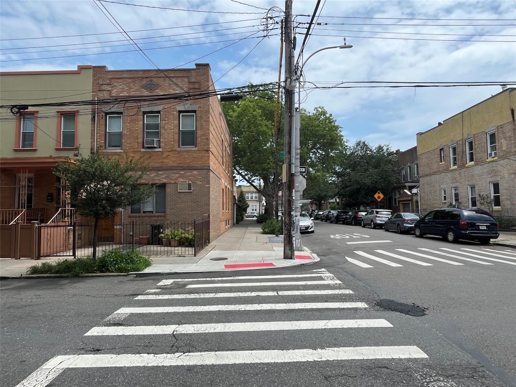 7447 62nd St, Glendale, NY 11385 - view of asphalt street with street lights, sidewalks, traffic signs, and curbs