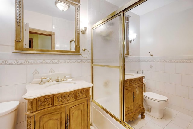 1478 Union St, Brooklyn, NY 11213 - bathroom featuring tile walls, vanity, bath / shower combo with glass door, a wainscoted wall, and tile patterned flooring