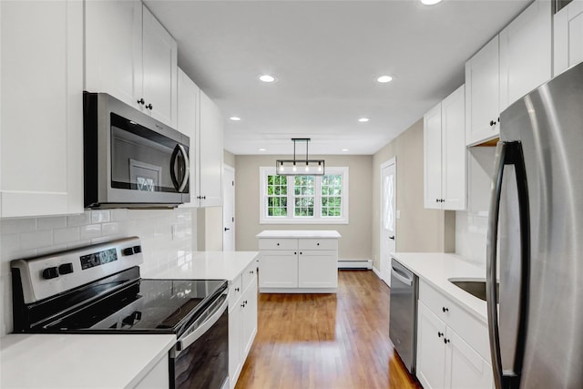 31 Tappan Ave, Babylon, NY 11702 - kitchen with appliances with stainless steel finishes, a baseboard radiator, light wood finished floors, light countertops, and white cabinetry