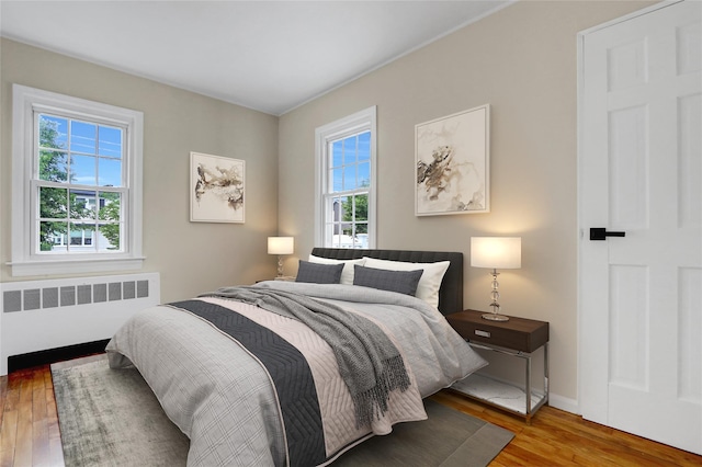 31 Tappan Ave, Babylon, NY 11702 - bedroom featuring radiator heating unit, multiple windows, and wood finished floors